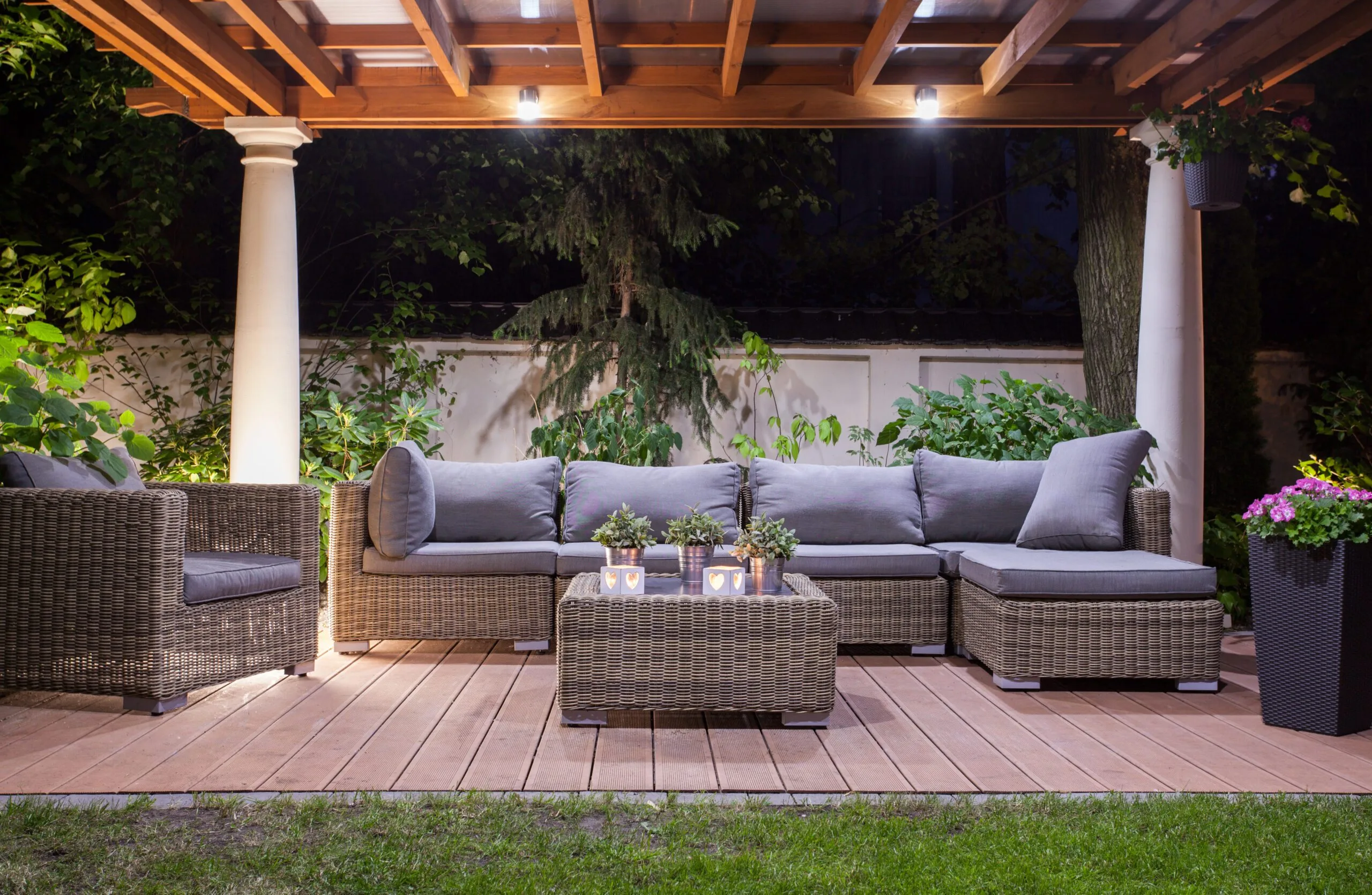 Residential backyard with outdoor furniture and canopy with lights.